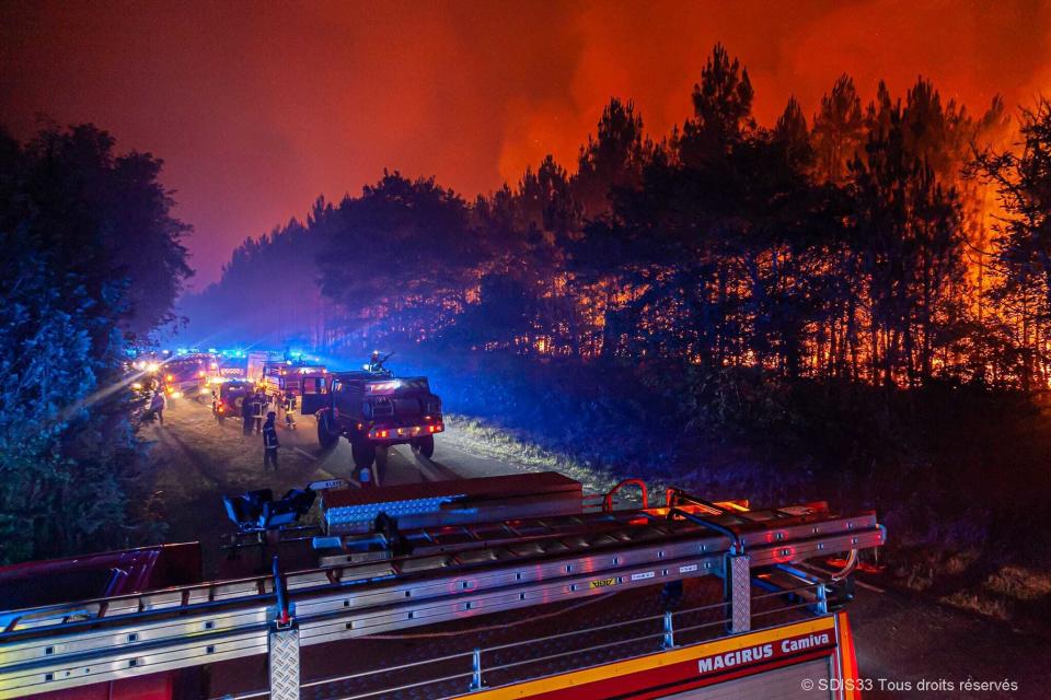 This photo provided by the fire brigade of the Gironde region (SDIS 33) shows firefighters fighting wildfire near Landiras, southwestern France, Sunday July 17, 2022 . Firefighters battled wildfires raging out of control in France and Spain on Sunday as Europe wilted under an unusually extreme heat wave that authorities in Madrid blamed for hundreds of deaths. (SDIS 33 via AP)