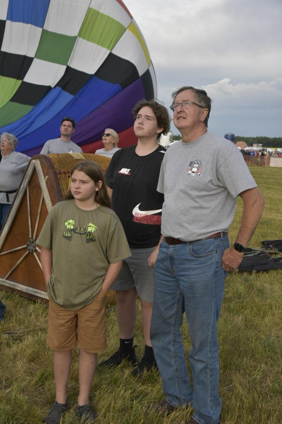 Pat Rolfe and his grandchildren, Madison Guilfoyle and Trevor Guilfoyle, watch as balloons launch from the Battle Creek Executive Airport in Battle Creek Friday, July 1, 2022.