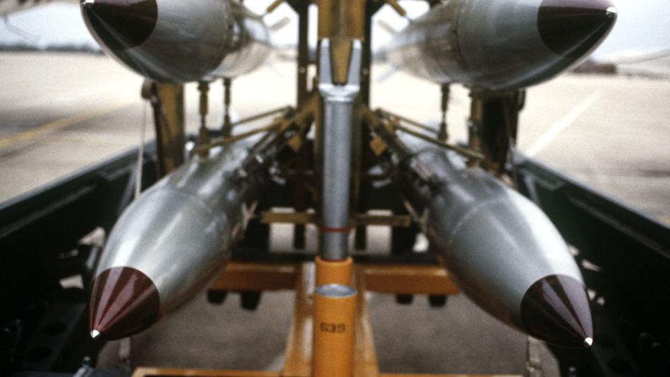 a front view of four nuclear free fall bombs on a bomb cart