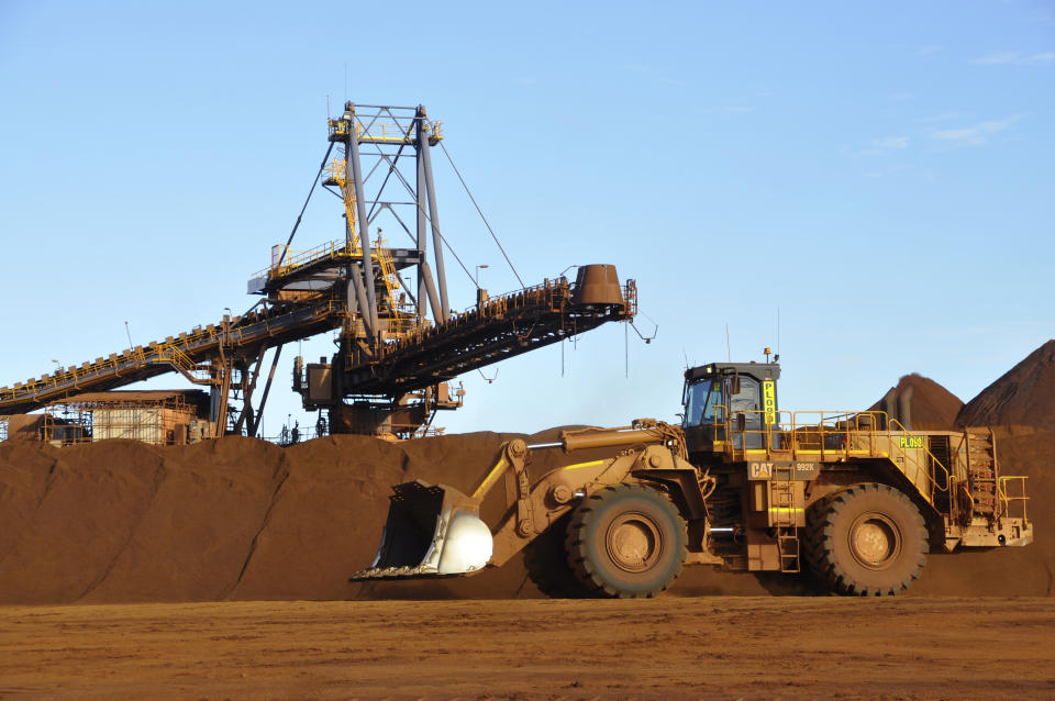 Earth moving equipment work at the site of Fortescue Metals Group's Christmas Creek iron ore operations in the Pilbara region of Western Australia, June 17, 2014. Australian iron ore miner Fortescue Metals Group has announced, Tuesday, Sept. 20, 2022, a $6.2 billion plan to eliminate fossil fuels and carbon emissions from its operations by the end of the decade. (AAP Image/Kim Christian)