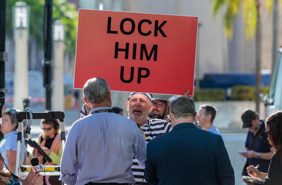 An anti-Trump holds a sign outside at the Wilkie D. Ferguson Jr. U.S. Courthouse, Tuesday, June 13, 2023, in Miami. Prior Former President Donald Trump is making a federal court appearance on dozens of felony charges accusing him of illegally hoarding classified documents.