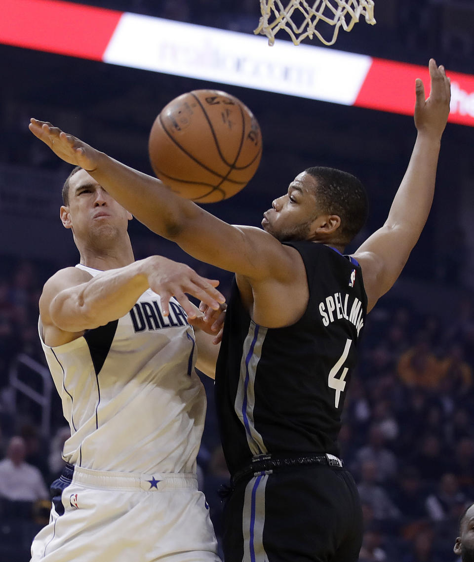 Dallas Mavericks' Dwight Powell, left, passes the ball away from Golden State Warriors' Omari Spellman (4) during the first half of an NBA basketball game Tuesday, Jan. 14, 2020, in San Francisco. (AP Photo/Ben Margot)