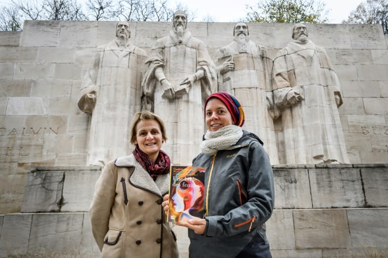 Geneva theology professors Elisabeth Parmentier (L) and Lauriane Savoy pose under the Reformation Wall with a copy of "A Women's Bible"