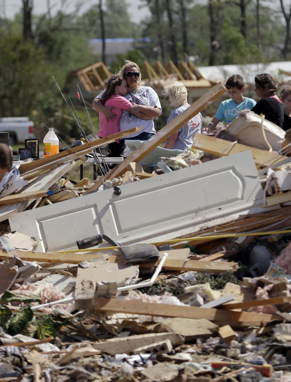 Residents and friends sift through debris after a tornado struck the area Monday, April 28, 2014, in Vilonia, Ark. A dangerous storm system that spawned a chain of deadly tornadoes killed dozens from the Midwest to the Deep South. (AP Photo/Eric Gay)