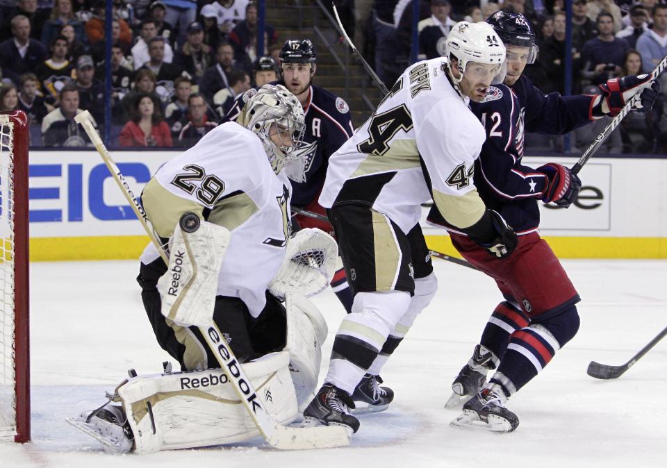 Pittsburgh Penguins' Marc-Andre Fleury, left, makes a save as teammate Brooks Orpik, center, and Columbus Blue Jackets' Artem Anisimov, of Russia, fight for position in front of the goal during the second period of Game 4 of a first-round NHL hockey playoff series on Wednesday, April 23, 2014, in Columbus, Ohio. (AP Photo/Jay LaPrete)