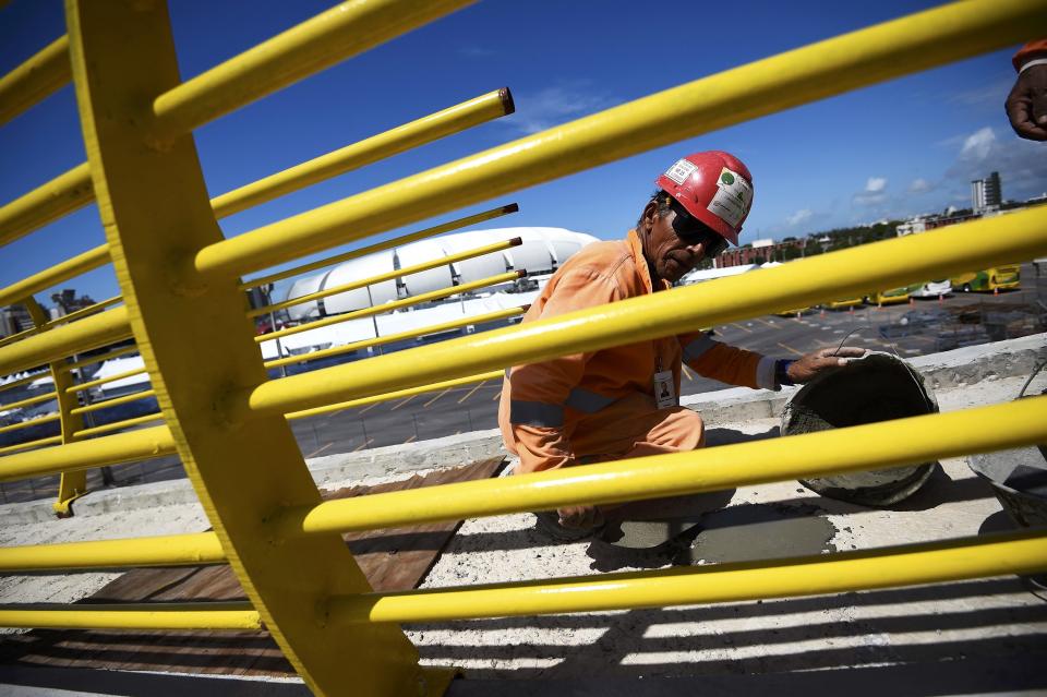 A construction worker lays concrete on a bridge next to the Dunas arena soccer stadium in Natal, June 12 , 2014. Mexico will face Cameroon in their 2014 World Cup football match here on June 13. REUTERS/Dylan Martinez