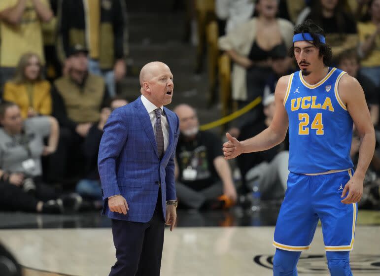 UCLA head coach Mick Cronin confers with guard Jaime Jaquez Jr. (24) in the first half of an NCAA college basketball game Sunday, Feb. 26, 2023, in Denver. (AP Photo/David Zalubowski)