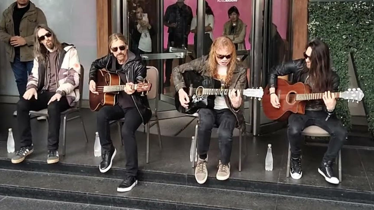  Megadeth performing with acoustic guitars on a street in 2024. 