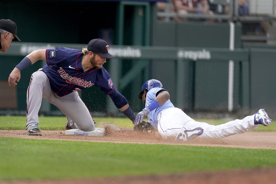 Kansas City Royals' Jarrod Dyson beats the tag by Minnesota Twins third baseman Josh Donaldson to advance to third on a ground out hit into by Jorge Soler during the ninth inning of a baseball game Saturday, June 5, 2021, in Kansas City, Mo. The Twins won 5-4. (AP Photo/Charlie Riedel)