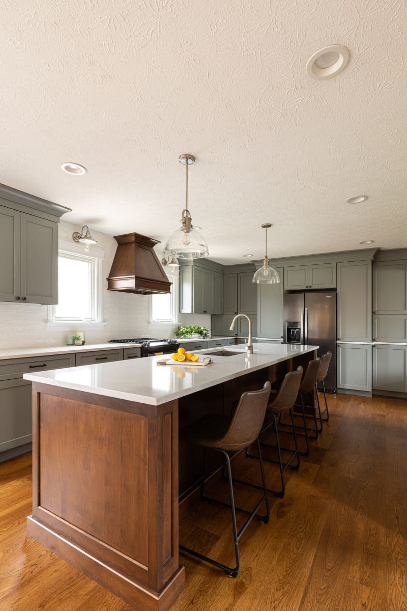 Glass pendant lamps over wooden kitchen island.