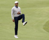 U.S. team player and captain Tiger Woods stretches his leg on the 7th fairway in their foursomes match during the President's Cup golf tournament at Royal Melbourne Golf Club in Melbourne, Friday, Dec. 13, 2019. (AP Photo/Andy Brownbill)