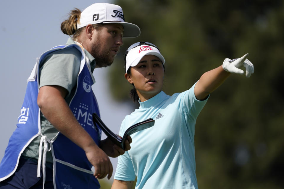 Danielle Kang, right, confers with her caddie on the fifth tee during the first round of the MEDIHEAL Championship golf tournament Thursday, Oct. 6, 2022, in Somis, Calif. (AP Photo/Mark J. Terrill)