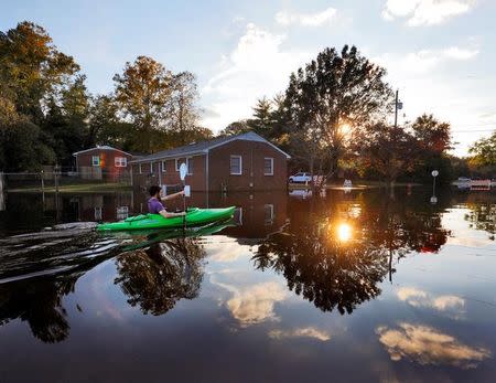 A resident paddles his kayak out of his neighborhood after checking the condition of his house as river levels rise into town in the aftermath of Hurricane Matthew, in Greenville, North Carolina, U.S. October 14, 2016. REUTERS/Jonathan Drake