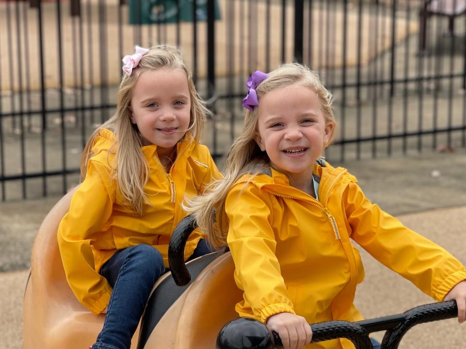 Identical twins Aliza and Eliana Hefner sitting in a playground
