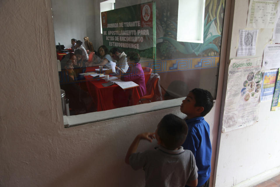 In this Tuesday, July 10, 2012 photo, U.S. born children watch as other families try to get their children's U.S. birth certificate stamped by Mexican authorities in Malinalco, Mexico. Because of the Byzantine rules of Mexican and U.S. bureaucracies, tens of thousands of U.S. born children of Mexican migrant parents now find themselves without access to basic services in Mexico - unable to officially register in school or sign up for health care at public hospitals and clinics that give free check-ups and medicines. (AP Photo/Dario Lopez-Mills)