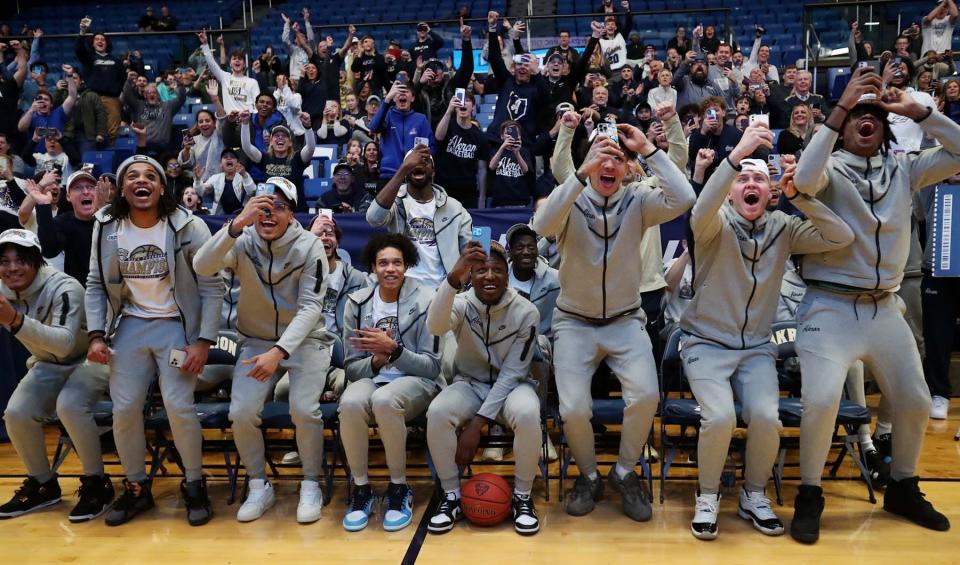 The University of Akron men's basketball team reacts to learning they will play UCLA in Portland in the first round of the NCAA tournament as they sit in front of their fans at the James A. Rhodes Arena on the campus Sunday.