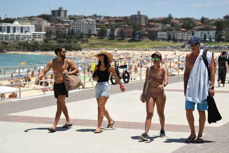 People seen on the sand during heatwave conditions at Bondi Beach in Sydney, Saturday.