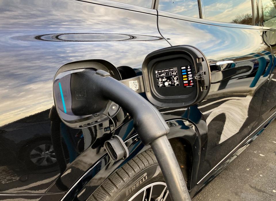 A close up of the 2023 Mercedes-Benz EQS SUV's charging port with an EV charger inserted.