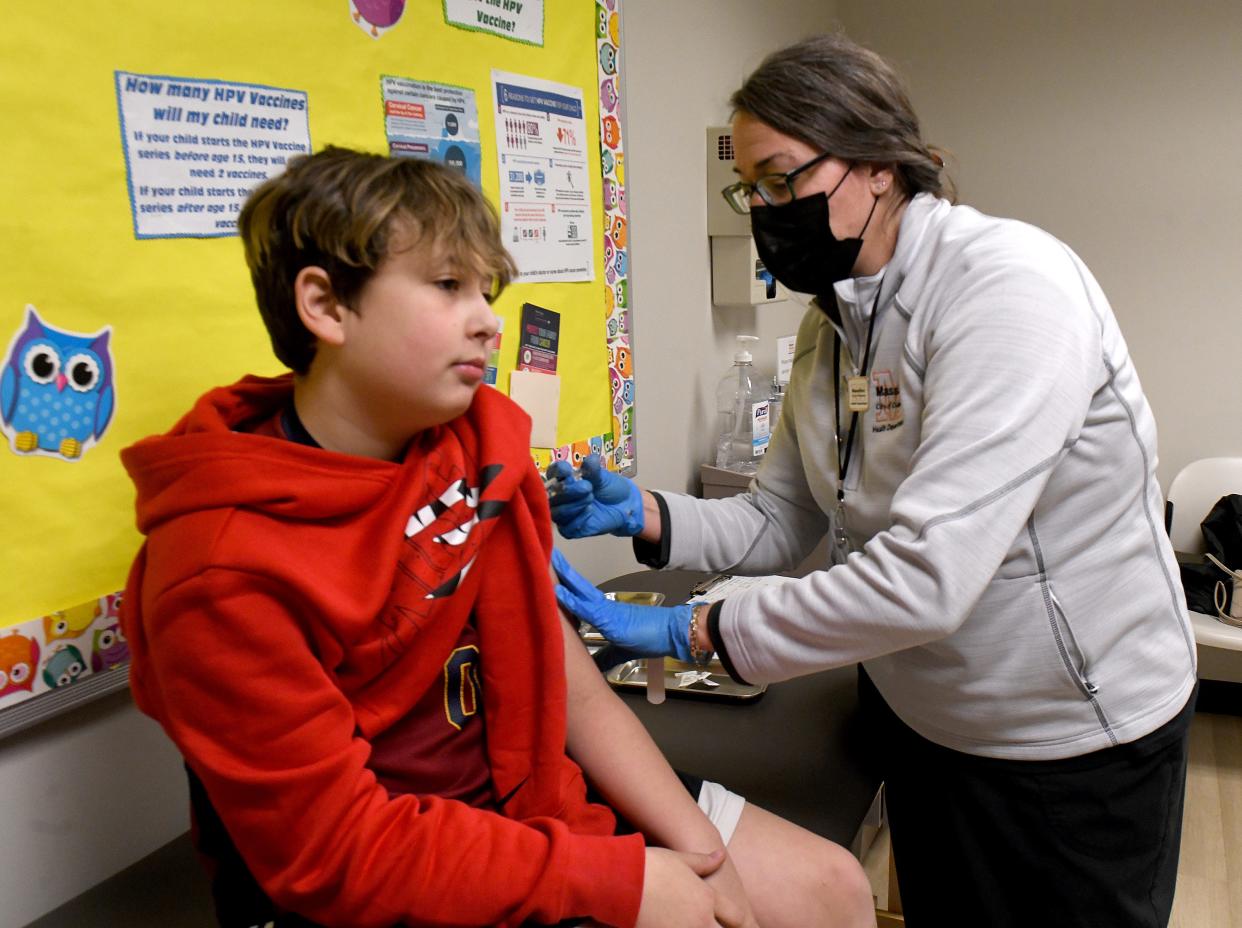 Registered nurse Christine Gogerty, right, administers a flu shot to Leo Vignos, 12, on Thursday, Dec. 7, 2023, at the Massillon Health Department. As of Thursday, the health agency has administered 99 flu shots to city residents.