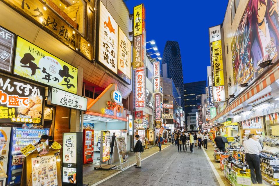 crowds of people walking among illuminated neon signs on the streets of tokyo, japan