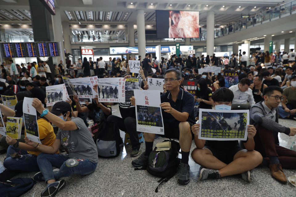 Protesters demonstrate at the airport in Hong Kong on Friday, Aug. 9, 2019. Pro-democracy protesters held a demonstration at Hong Kong's airport Friday even as the city sought to reassure visitors to the city after several countries issued travel safety warnings related to the increasing levels of violence surrounding the two-month-old protest movement. (AP Photo/Vincent Thian)