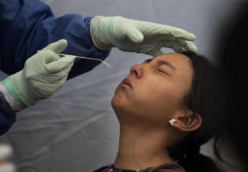 A young woman gets tested for COVID-19 at a health center in Salesiano park, in the Miguel Hidalgo district of Mexico City, Wednesday, July 15, 2020. (AP Photo/Marco Ugarte)