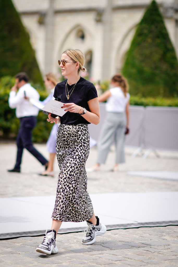 <p>A woman attends Paris Fashion Week wearing a black T-shirt, leopard-print skirt, and Louis Vuitton sneakers outside the Christian Dior haute couture fall winter 2018/2019, on July 2, 2018, in Paris. (Photo: Edward Berthelot/Getty Images) </p>