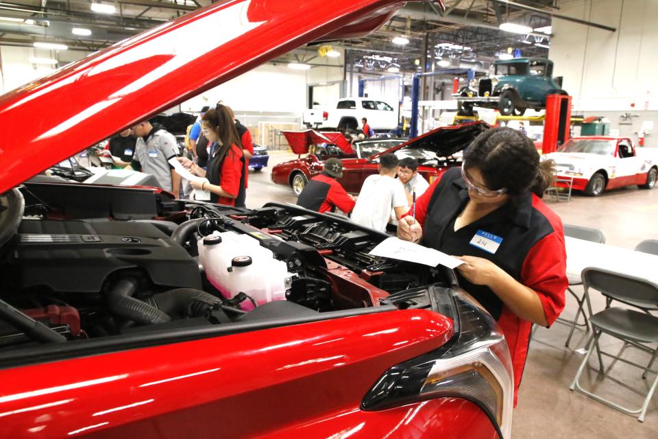 Victoria Martinez of Piedra Vista High School checks the engine of a pickup truck at one of the stations in the Skills USA competition at San Juan College on Friday, Nov. 17.