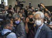 Martin Lee, 82-year-old lawyer and former lawmaker, right, leaves a court after receiving a suspended sentence in Hong Kong Friday, April 16, 2021. A Hong Kong court on Friday sentenced five leading pro-democracy advocates, including media tycoon Jimmy Lai, to up to 18 months in prison for organizing a march during the 2019 anti-government protests that triggered an overwhelming crackdown from Beijing. (AP Photo/Vincent Yu)