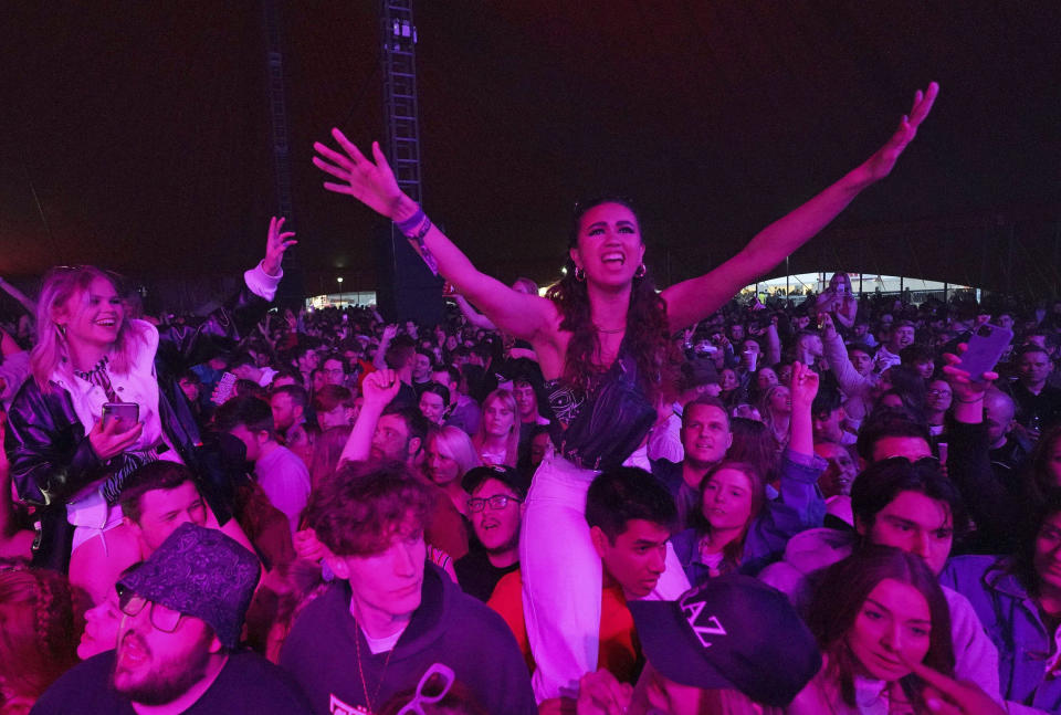 Revellers react during the nation's first music festival, free of coronavirus restrictions, at Sefton Park in Liverpool, England, as part of the national Events Research Programme (ERP), Sunday May 2, 2021. The live music festival, with festival goers able to not wear face coverings or observe social distancing, while authorities research virus effects of the event. (Danny Lawson/PA via AP)