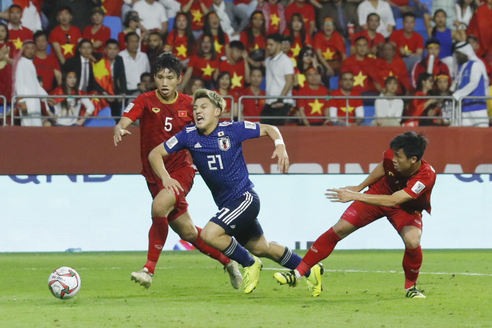 Japan's midfielder Ritsu Doan, centre, is fouled during the AFC Asian Cup quarterfinal soccer match between Japan and Vietnam at Al Maktoum Stadium in Dubai, United Arab Emirates, Thursday, Jan. 24, 2019. (AP Photo/Hassan Ammar)