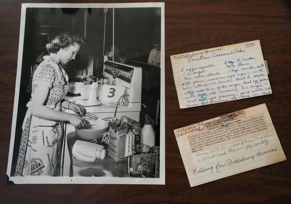 Arlene McCardle at age 20, baking her Pillsbury regional winning Venetian Cocoanut Cake in the competition at the Waldorf Astoria Hotel in New York. Her original recipe cards are displayed next to the photo.