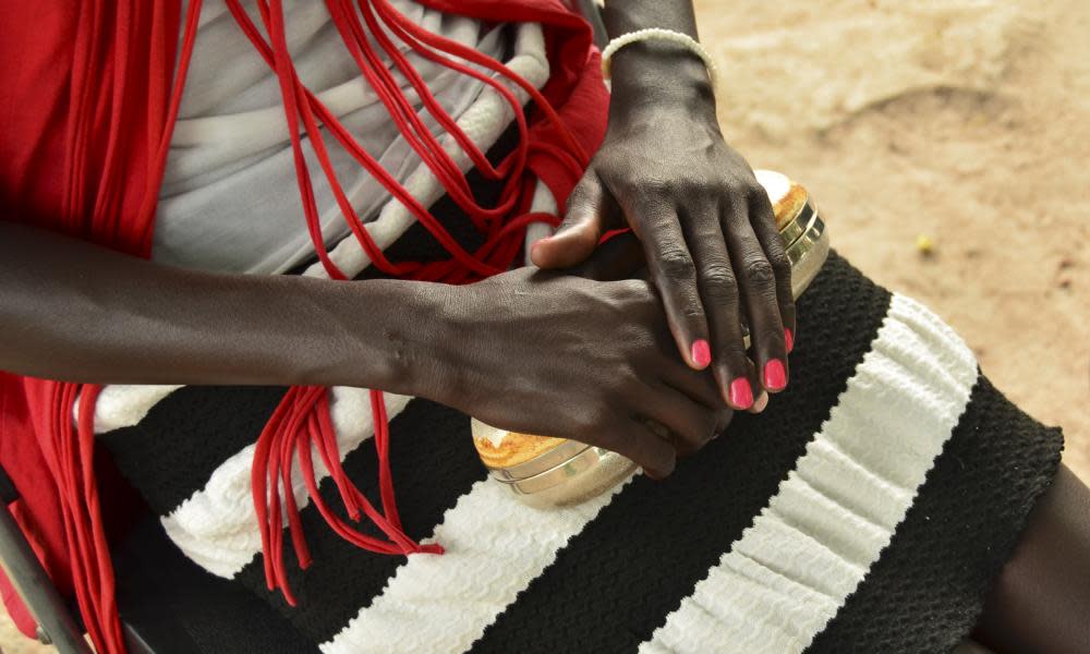 A woman clutches a gold handbag