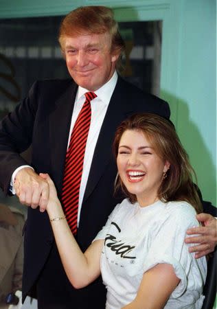 Miss Universe 1996, Alicia Machado of Venezuela, (R) is greeted by businessman Donald Trump during a staged workout at a gym in New York in a January 28, 1997 file photo. REUTERS/Peter Morgan/Files