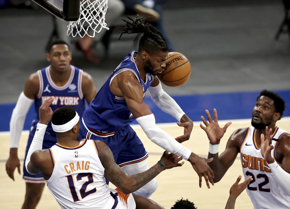 New York Knicks' Reggie Bullock, top center, fights for a rebound with Phoenix Suns' Torrey Craig (12) and Deandre Ayton (22) in the third quarter of an NBA basketball game Monday, April 26, 2021, in New York. (Elsa/Pool Photo via AP)