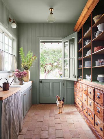 <p>Cody Ulrich</p> Walls painted in Sherwin-Williamsâ Evergreen Fog (SW 9130) and terra- cotta pavers from Austin-based Clay Imports round out the mudroom.