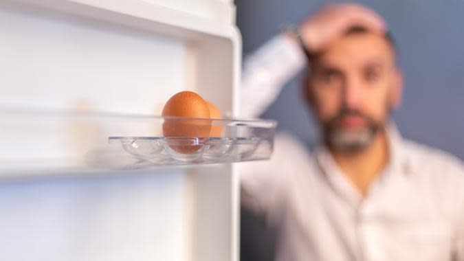 Man looking at 2 eggs in a refrigerator. (iStock.com)