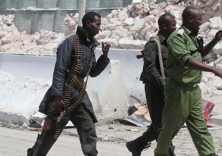 Somali policemen walk towards the scene of a suicide bombing near the African Union's main peacekeeping base in Mogadishu, Somalia, July 26, 2016. REUTERS/Ismail Taxta