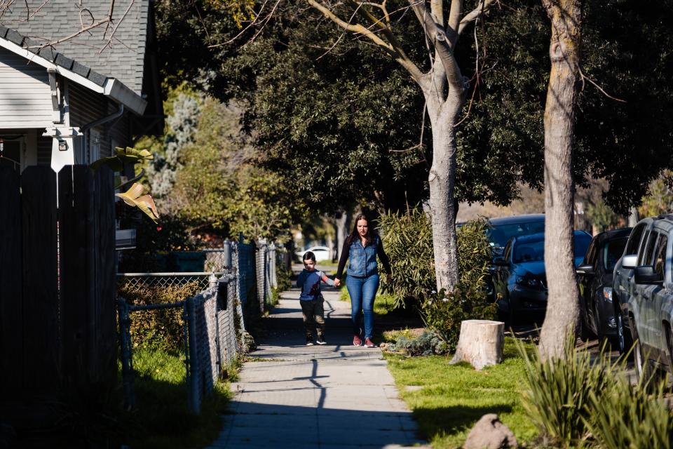 A mother and son walk through one of the neighborhoods of Stockton where participants in the city's universal basic income program live in Stockton, California on February 7, 2020. - The scoffed-at idea of paying everyone a basic income as machines take people's jobs is getting a fresh look as a possible remedy for economies cratered by the coronavirus pandemic. (Photo by Nick Otto / AFP) (Photo by NICK OTTO/AFP via Getty Images)