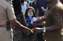 A stranded Kashmiri girl anxiously looks at officials checking documents as she waits with elders to board a bus to a special train home during a lockdown to curb the spread of new coronavirus, in Bangalore, India, Sunday, May 10, 2020. India's lockdown entered a sixth week on Sunday, though some restrictions have been eased for self-employed people unable to access government support to return to work. (Aijaz Rahi)