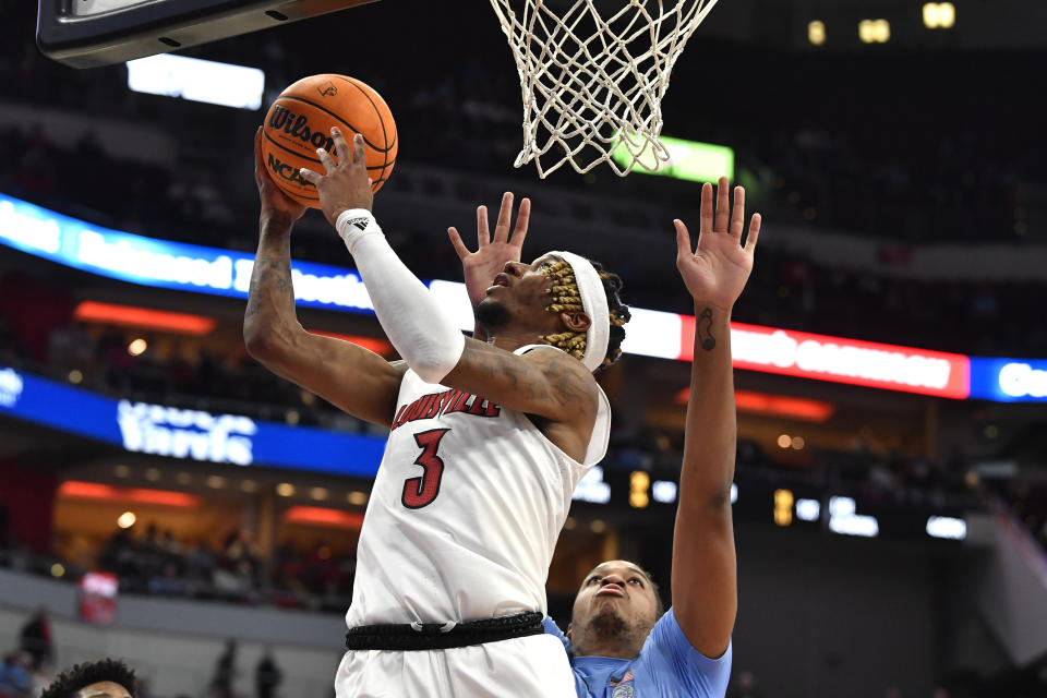 Louisville guard El Ellis (3) goes in for a layup around North Carolina forward Armando Bacot (5) during the second half of an NCAA college basketball game in Louisville, Ky., Saturday, Jan. 14, 2023. North Carolina won 80-59. (AP Photo/Timothy D. Easley)