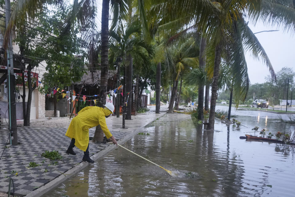 Un hombre limpia un desagüe después del paso del huracán Beryl, el viernes 5 de julio de 2024, en Tulum, México. (AP Foto/Fernando Llano)