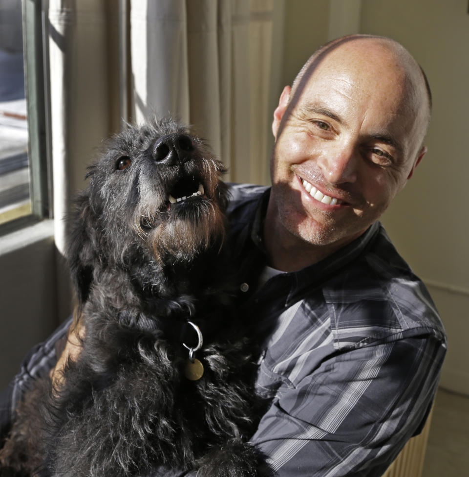 Martin Sprouse with 'Grady', an Airedale Terrier-Irish Wolfhound mix, Thursday, April 18, 2013, in Oakland, Calif. After his owner brought the dog to the Kauai Humane Society because he was moving, the dog with the big brown eyes languished for four months, said shelter operations manager Brandy Varvel. But now Grady is living in a spacious California loft with a new owner who is admittedly smitten thanks to an arrangement the Kauai Humane Society has with the East Bay SPCA in Oakland. The Kauai Humane Society has been reaching out since December to Hawaii tourists willing to bring a little extra baggage, one of the island’s many strays and abandoned dogs, when returning to the Bay Area. The dogs are mostly mixed breeds derived from Airedales, whippets and hounds; breeds which are used in the Hawaii Islands to hunt feral pigs. (AP Photo/Ben Margot)