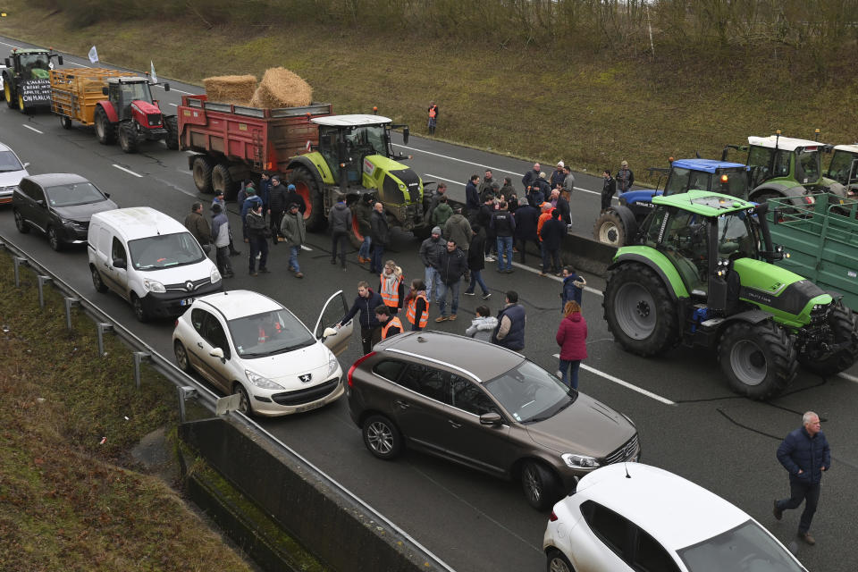 Farmers block a highway during a demonstration Tuesday, Jan. 23, 2024 near Beauvais, northern France. Farmers have for months been protesting for better pay and against what they consider to be excessive regulation, mounting costs and other problems. (AP Photo/Matthieu Mirville)