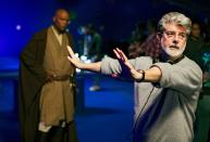 <p>Am Set von “Die Rache der Sith”: George Lucas erklärt Einzelheiten einer Szene, was der Mace-Windu-Darsteller Samuel L. Jackson im Hintergrund gespannt beobachtet. (Bild: ddp/Shooting Star/Sipa USA) </p>