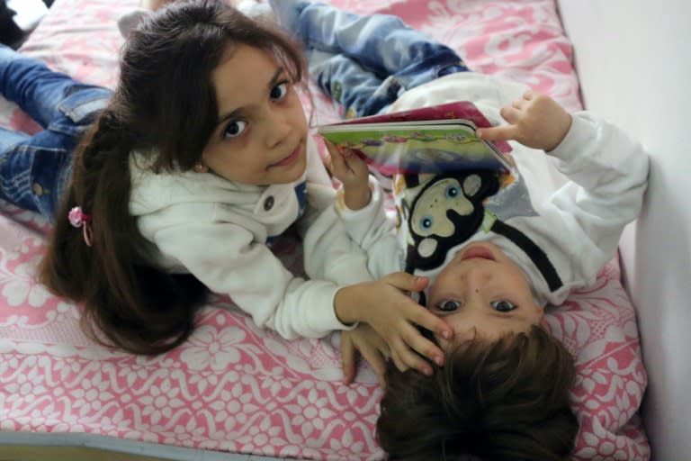 Syrian Bana al-Abed plays with her brother in east Aleppo on October 10, 2016