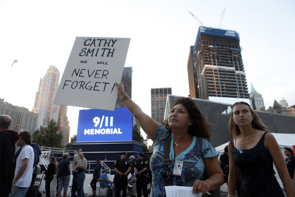 Elba Cedeno, of Waretown, N.J., holds a sign memorializing her partner, Catherine Theresa Smith, as friends and relatives of the victims of 9/11 gather for a ceremony marking the 10th anniversary of the attacks at the National September 11 Memorial at the World Trade Center site, Sunday, Sept. 11, 2011, in New York. (AP Photo/Jason DeCrow)