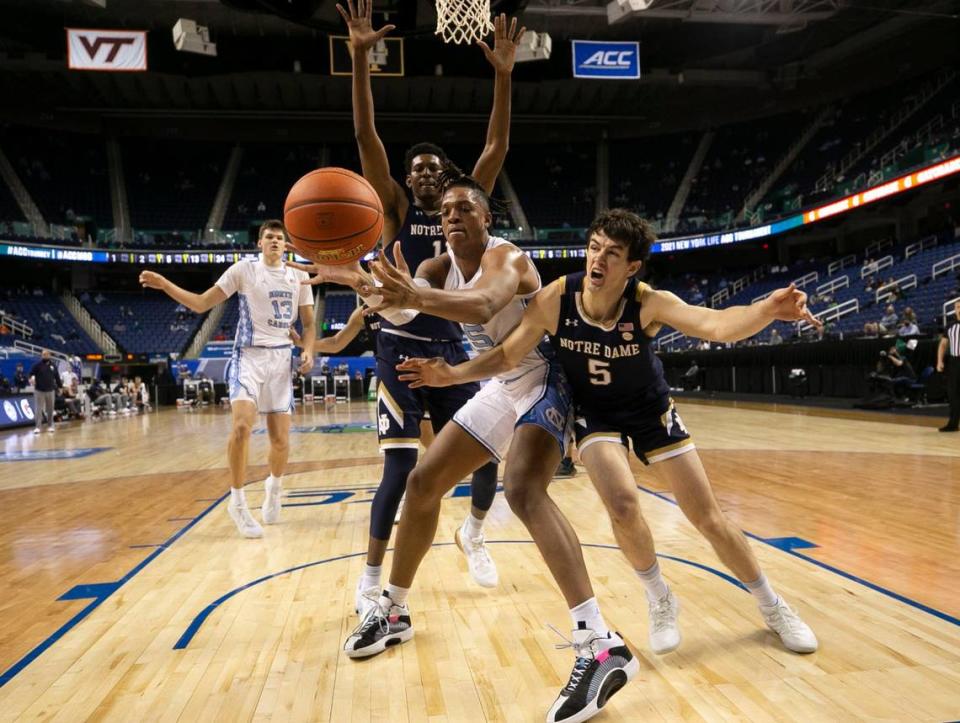 North Carolina’s Armando Bacot (5) battles for a loose ball with Notre Dame’s Cormac Ryan (5) during the second half on Wednesday, March 10, 2021 during the ACC Tournament at the Greensboro Coliseum in Greensboro, N.C.