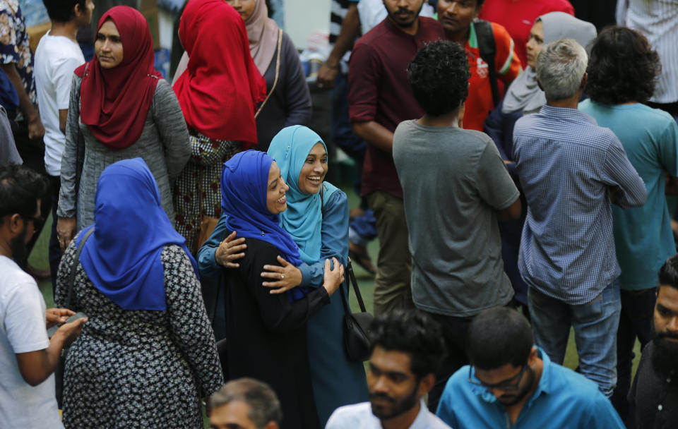 Two Maldivian women share a happy moment as they wait to caste their vote at a polling station during presidential election voting day in Male, Maldives, Sunday, Sept. 23, 2018. Huge crowds flocked to closely guarded polling stations on Sunday to vote in the Maldives' third multiparty presidential elections, widely seen as a referendum on the island nation's young democracy. (AP Photo/Eranga Jayawardena)