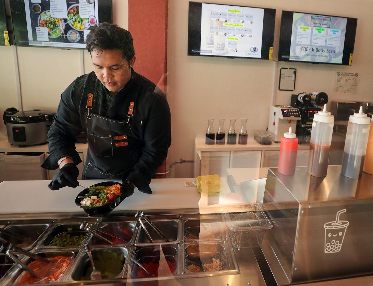 Jason Gontinas dishes up a poke bowl behind the counter of his newly opened Poke & Prep restaurant in downtown Bremerton on Thursday.